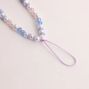 Detail of beaded mobile strap with pastel pearls, blue beads, and purple accents