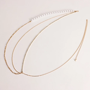 Detail of layered gold waist chain with pearls, rhinestones, and chunky metal links