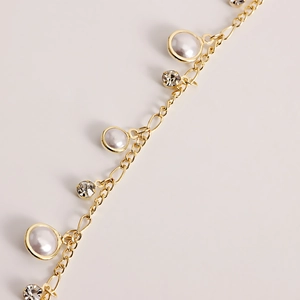 Detail of gold fringe chain with pearls and zircon crystals for waist styling
