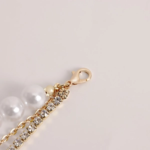 Detailed view of layered waist chain with pearls, gold links and sparkling rhinestones