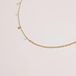 Detail of gold waist chain featuring star charms and sparkling zircon stones