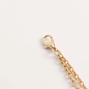 Détail du fermoir mousqueton doré et de la fine chaîne à maillons pour bijoux de corps