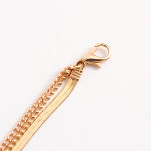 Detail van de dubbellaagse gouden slangenketting met stevige karabijnsluiting en glans