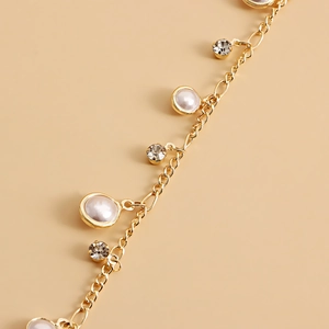 Elegant gold metal waist chain with faux pearls and sparkling cubic zirconia tassels
