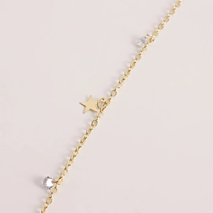 Detailed close-up of golden waist chain featuring a pentagram pendant and clear zircons