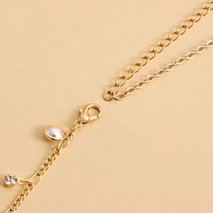 Gold chain belt with pearl and rhinestone charms featuring a secure lobster clasp closure