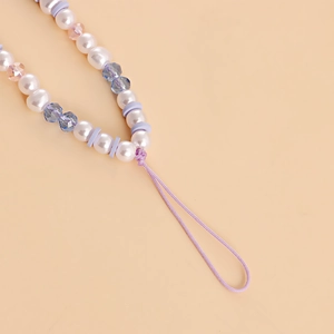 Close-up of handmade beaded phone strap with purple ceramic and faceted glass beads