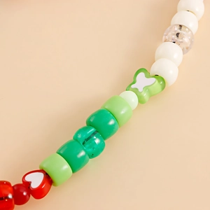 Macro shot of colorful handmade resin beads featuring heart and bow shapes for phone lanyard