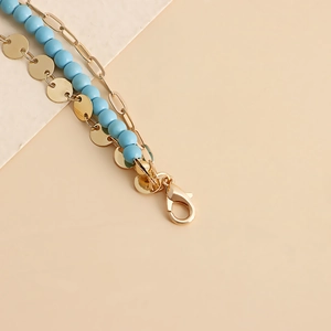 Detail of bohemian gold chain waist belt with blue turquoise beads and metal sequins