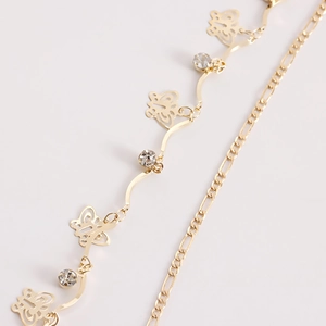 Detail of gold butterfly pendant waist chain with zircon stones and Figaro link layers