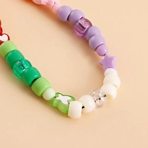 Macro detail of colorful beaded phone strap with acrylic heart and star shaped charms
