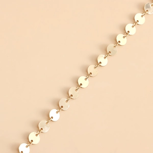 Detail of bohemian gold layered chain featuring flat circular discs and turquoise starfish charms