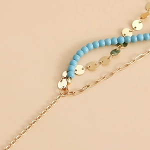 Detail of layered bohemian waist chain featuring turquoise beads and golden coin charms
