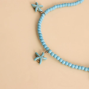 Close-up of blue beads and vintage starfish pendants on a bohemian waist chain