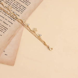 Close-up of golden double-layered butterfly chain with sparkling white zircons