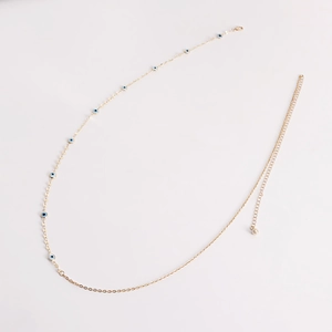 Detail of adjustable gold waist chain featuring evil eye charms and metal discs