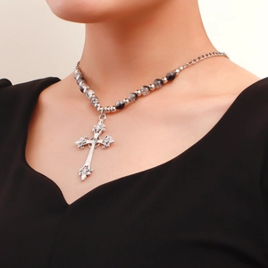 Detail of vintage silver cross pendant with black and clear cracked crystal beads