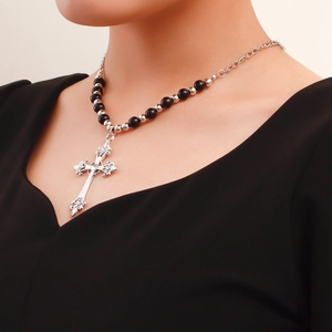 Detail of vintage layered cross necklace with silver filigree pendant and beaded chain