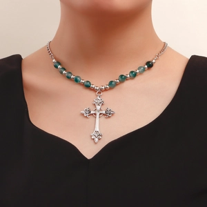 Close-up of vintage beaded necklace with a silver hollowed-out cross pendant for women