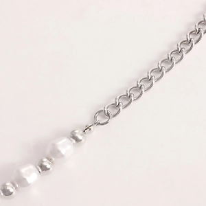 Detail of silver chain necklace with white baroque pearls and polished metallic beads