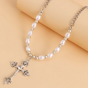 Detailed close-up of a vintage cross pendant featuring intricate patterns and pearls