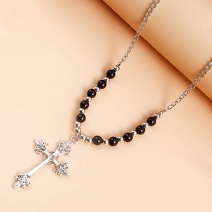 Macro view of vintage engraved cross pendant with white rhinestone and bead chain