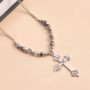 Detailed close-up of a vintage silver cross pendant with grey marble beads and fine chain