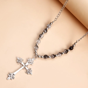 Macro detail of retro silver cross pendant with marble beads and crystal inlay