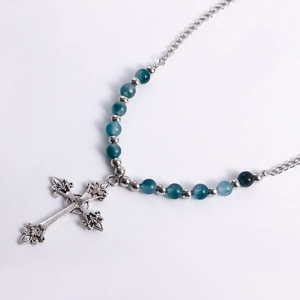 Macro detail of retro cross pendant with blue gradient beads and silver metal balls