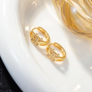 Detail of gold butterfly hoop earrings featuring micro-pave cubic zirconia crystals
