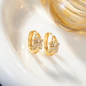 Close-up of gold plated hoop earrings with marquise zircon leaves in a ceramic dish