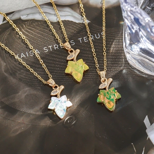 Detailed close-up of French vintage maple leaf pendants in white, green, and orange finishes