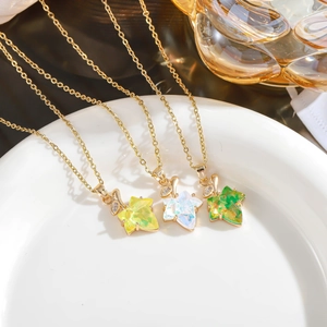 Macro detail of three maple leaf pendants in green, yellow and iridescent finishes