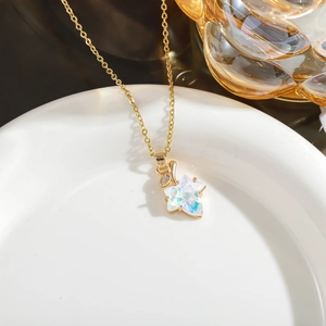 Macro shot of iridescent star pendant on gold chain with detailed leaf zircon accent