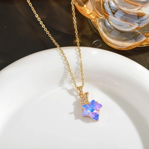 Detailed macro of golden necklace featuring a shimmering maple leaf crystal pendant