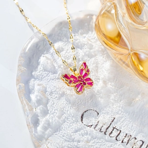 Close-up of butterfly pendant with pink purple baguette zircon in gold setting