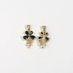 Macro view of gold flower pendant with black pear-shaped gems and tassel details