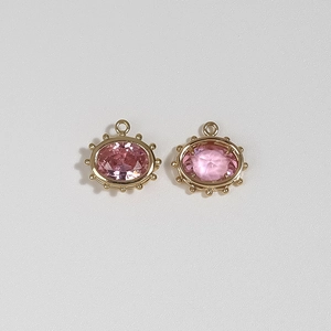 Macro shot of pink gemstone evil eye pendants with gold plated beaded edge for DIY jewelry