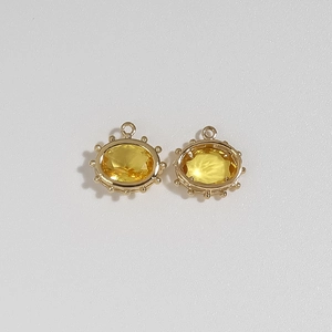 Macro view of gold plated evil eye charms with faceted yellow gemstones and bead details