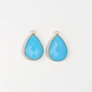 Detail of tear-drop blue glass pendants with gold-plated edges for DIY jewelry making