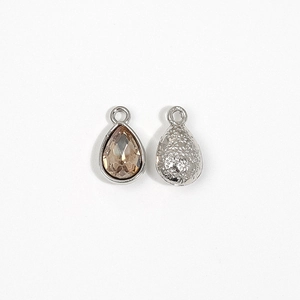Detail view of water drop charms with champagne crystals and textured silver metal backs