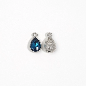 Macro detail of teardrop blue crystal pendant with silver textured back for DIY jewelry