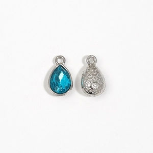 Macro view of silver teardrop alloy pendant with blue crystal for DIY jewelry
