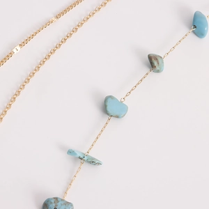 Vue détaillée d'une chaîne de taille dorée bohème avec pierres de turquoise bleues