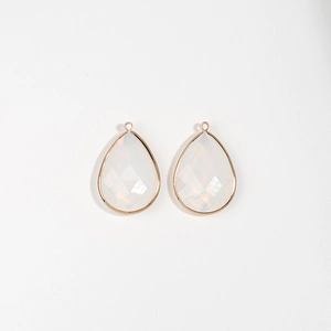Detail of tear-drop white stone charms with gold-plated copper edges for DIY jewelry