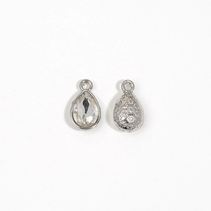 Detailed view of silver teardrop crystal charm with a pear-cut stone and textured back