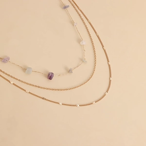 Détail d'une chaîne de taille dorée à trois rangs avec perles en pierres naturelles bohèmes