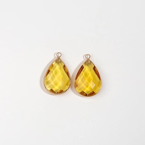 Detail of yellow faceted teardrop pendant with gold metal frame for DIY jewelry making