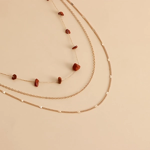 Détail de chaînes de taille dorées multicouches avec pierres de turquoise naturelles