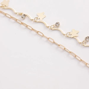 Close-up of gold double-layer waist chain featuring butterfly pendant and crystals